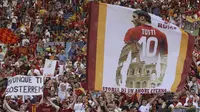 Supporter membawa bendera raksasa bergambar Francesco Totti saat laga terakhir sang legenda di Stadion Olimpico, Roma, Minggu (28/5/2017). Selama 25 tahun Totti berkarier di AS Roma. (AP/Alessandra Tarantino)