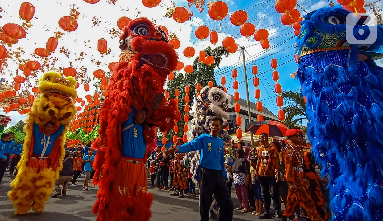 Atraksi barongsai memeriahkan karnaval  budaya saat Festival Grebeg Sudiro di kawasan Pasar Gede, Surakarta, Jawa Tengah, Minggu ( 19/1/2020). Grebeg Sudiro merupakan acara tahunan untuk menyambut Tahun Baru Imlek. (Liputan6.com/Gholib)