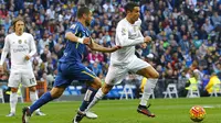 Bintang Real Madrid, Cristiano Ronaldo, melewati hadangan pemain Getafe, Mehdi Lacen, pada laga La Liga di Stadion Santiago Bernabeu, Spanyol, Sabtu (5/12/2015). (EPA/J.P.Gandul)