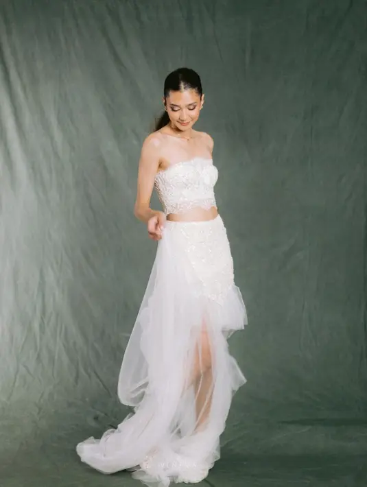 Dengan aksen renda pada bustier serta tule pada rok untuk memberi romantisme pada bride. [@venemapictures]