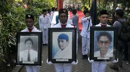 Mahasiswa dengan foto korban tragedi Mei mengikuti Peringatan 17 Tahun Tragedi 12 Mei 1998 di Universitas Trisakti, Jakarta, Selasa (12/5). Kegiatan tersebut untuk mengenang kembali empat mahasiswa Trisakti yang tewas tertembak. (Liputan6.com/Johan Tallo)