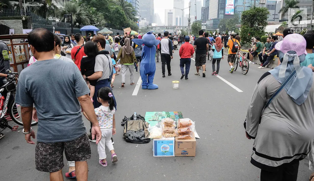 Pedagang Kaki Lima (PKL) berjualan selama kegiatan Car Free Day (CFD) di sepanjang Jalan Sudirman, Jakarta, Minggu (9/12). Kurangnya pengawasan menyebabkan banyak PKL yang berjualan tidak pada tempatnya dan memenuhi area CFD. (Liputan6.com/Faizal Fanani)
