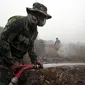 Seorang anggota TNI menyemprotkan air ke lahan gambut yang terbakar di Kampar, Riau, Jumat (11/9/2015). Sekitar 10.000 anggota TNI diterjunkan untuk membantu memadamkan kebakaran lahan yang terjadi di Sumatera. (REUTERS/YT Haryono)