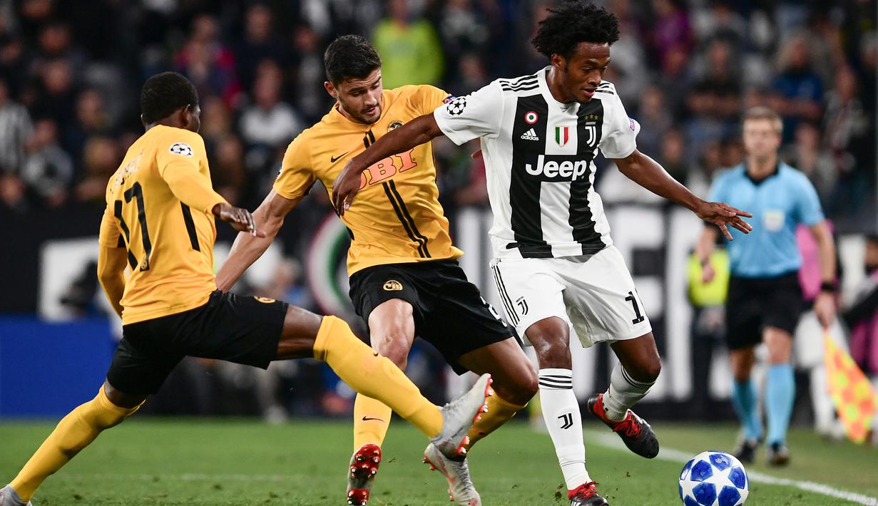 Gelandang Juventus, Juan Cuadrado, berusaha melewati bek Young Boys, Gregory Wuthrich, pada laga Liga Champions di Stadion Juventus, Turin, Selasa (2/10/2018). Juventus menang 3-0 atas Young Boys. (AFP/Marco Bertorello)