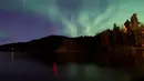 Aurora Borealis saat menerangi langit malam Desa Erikslund di Vasternorrland County, Swedia (23/8). Fenomena langka ini muncul dari tabrakan antara partikel gas di atmosfer bumi dengan partikel bermuatan dari matahari. (AFP PHOTO/ JONATHAN NACKSTRAND)