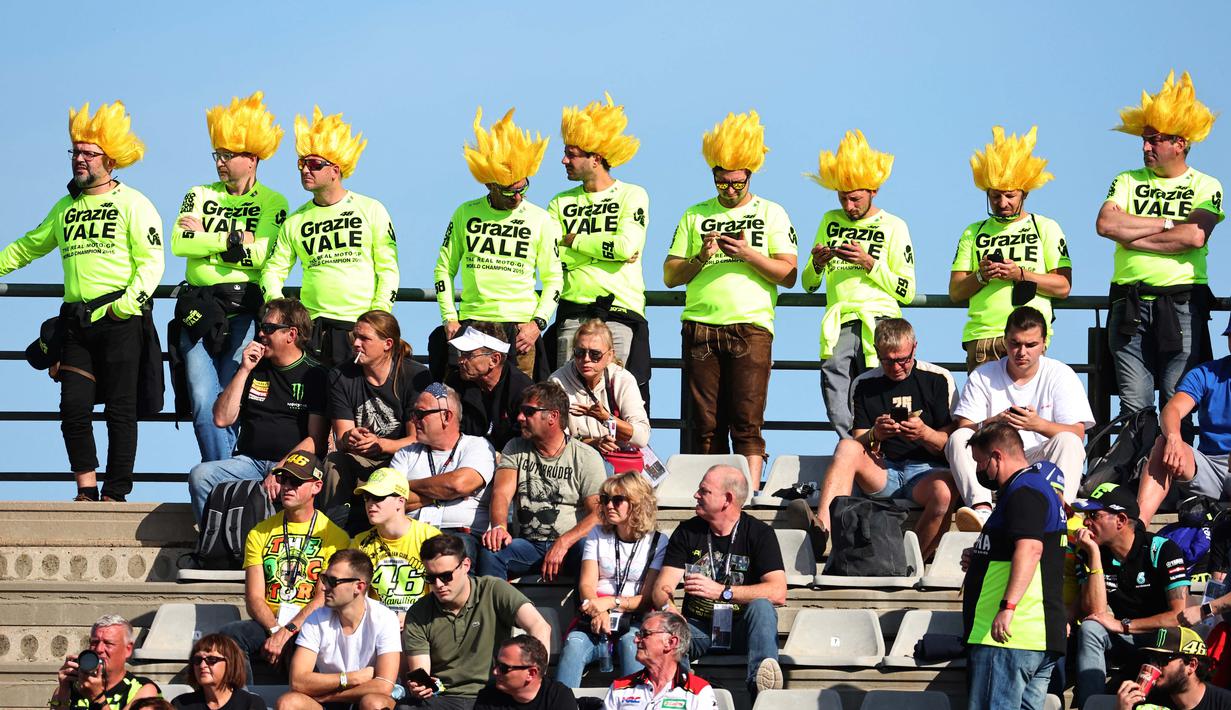 Mereka hadir untuk menyaksikan sang idola dari tribune Sirkuit Ricardo Tormo menggunakan baju dengan warna khas The Doctor dan juga rambut palsu. (AFP/Jose Jordan)