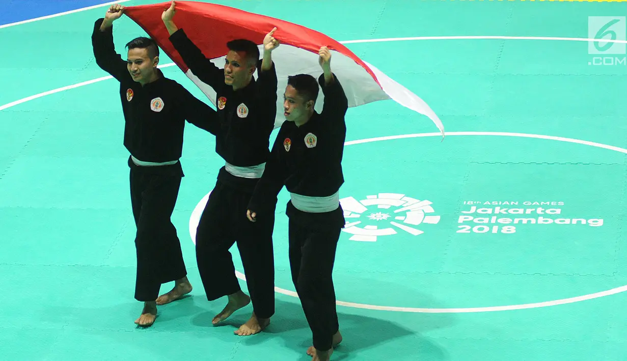Nunu Nugraha, Asep Yuldan Sani, dan Anggi Faisal Mubarok mengibarkan bendera Merah Putih usai tampil dalam babak final pencak silat beregu putra Asian Games 2018 di TMII, Jakarta, Senin (27/8). (Merdeka.com/Arie Basuki)