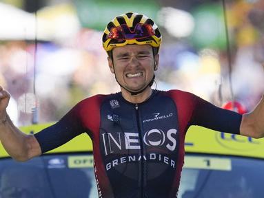 Pebalap tim Ineos Grenadiers, Thomas Pidcock melakukan selebrasi saat melintasi garis finis pada Stage 12 Tour de France 2022 yang menempuh rute sepanjang 165,1 km dari Briancon hingga L'Alpe-d'Huez, di Pegunungan Alpen, Prancis, Jumat (14/07/2022). (AP/Thibault Camus)