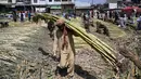 Seorang buruh Pakistan membawa tebu di sebuah pasar grosir sayuran di Islamabad (9/4). Populasi di kota ini mencapai dua juta penduduk yang merupakan kota terbesar ke-10 di Pakistan. (AFP Photo/Aamir Qureshi)