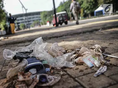 Sampah terlihat di area Stadion Utama Gelora Bung Karno setelah laga Final Piala Presiden 2018, Jakarta, Minggu (18/2). Kebanyakan sampah yang ada adalah bungkus makanan dan botol minuman yang dibiarkan tercecer begitu saja. (Liputan6.com/Faizal Fanani)