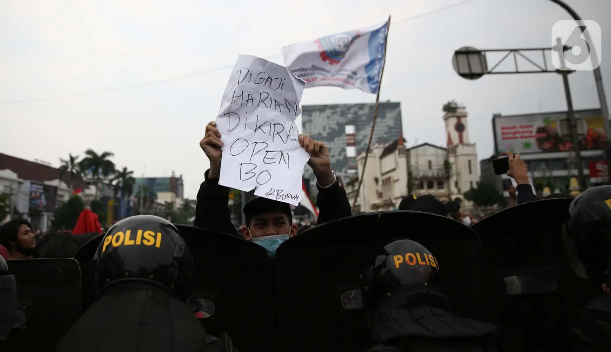 Pengunjuk rasa mengangkan poster saat berdemonstrasi menolak UU Cipta Kerja di kawasan Harmoni, Jakarta, Kamis (8/10/2020). UU Cipta Kerja yang disahkan beberapa waktu lalu memicu demonstasi sejumlah kalangan. (Liputan6.com/Faizal Fanani)