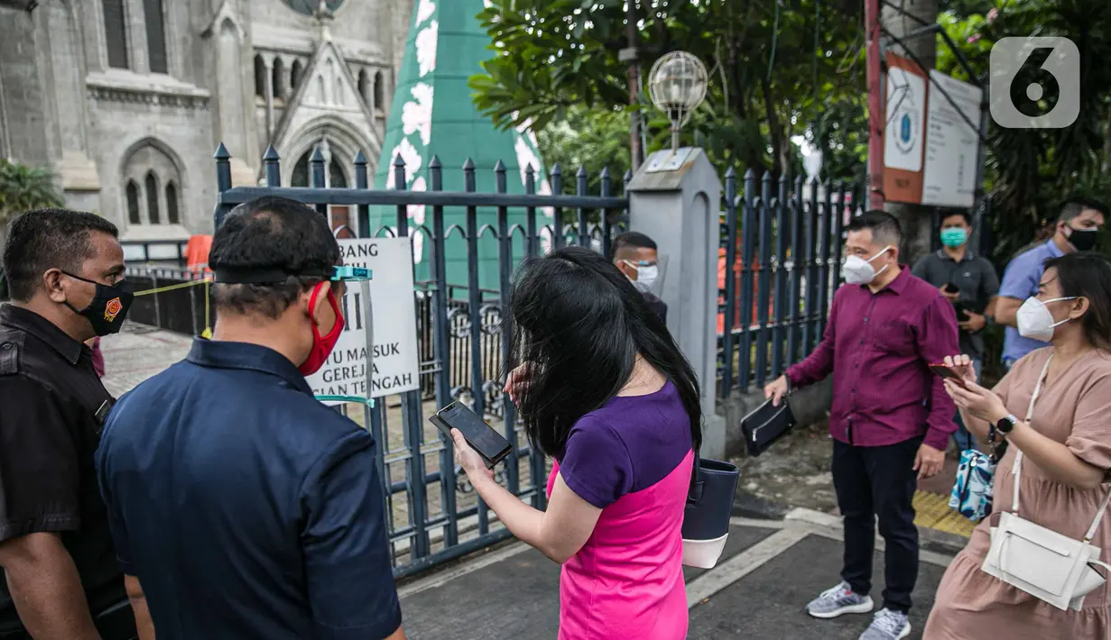 Para Jemaat memperlihatkan bukti pendaftaran untuk mengikuti ibadah di Gereja Katedral, Jakarta, Kamis (24/12/2020). Setiap selesai ibadat, Gereja Katedral melakukan disinfeksi di dalam dan seluruh ruang gereja. (Liputan6.com/Faizal Fanani)