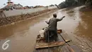 Pekerja saat menyebrangi perahu eretan di Kali Ciliwung, Jakarta, Senin (30/11). Tidak adanya fasilitas jembatan menyebabkan warga memilih eretan sebagai sarana penyeberangan sehari-hari, meskipun dengan kondisi seadanya. (Liputan6.com/Immnuel Antonius)