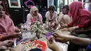 Dua WNA membuat kreasi daur ulang dari kulit bawang di Rumah Amalia, Ciledug, Kota Tangerang, Sabtu (3/3). Kegiatan ini bertujuan memperkenalkan program kreativitas kepada komunitas couchsurfing Indonesia terutama kepada WNA. (Liputan6.com/Fery Pradolo)