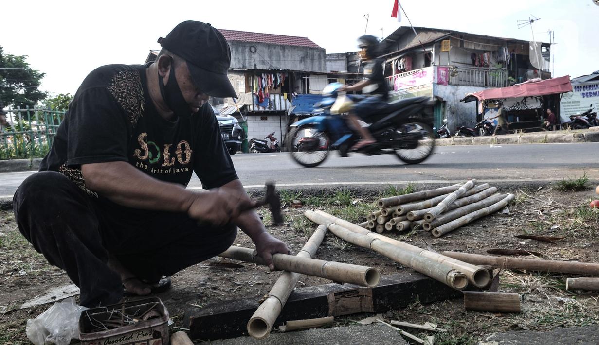 Seorang pedagang, Kusnadi (57) merakit pohon pinang di kawasan Manggarai, Jakarta, Selasa (11/8/2020). Penjualan pohon pinang tahun ini menurun drastis dibandingkan tahun sebelumnya akibat pandemi Covid-19 yang menyebabkan larangan sejumlah perlombaan. (merdeka.com/Iqbal Nugroho)