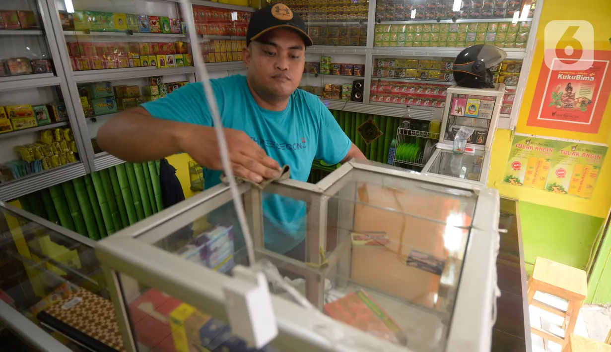 Hendri (37) membersihkan toko jamu aduk miliknya di kawasan Pamulang, Tangerang Selatan, Banten, Senin (28/9/2020). Menurutnya penjualan jamu aduk pada masa musim pandemi Covid 19 satu bulan ini penjualan meningkat hingga 200 persen dibandingkan bulan sebelumnya. (merdeka.com/Dwi Narwoko)