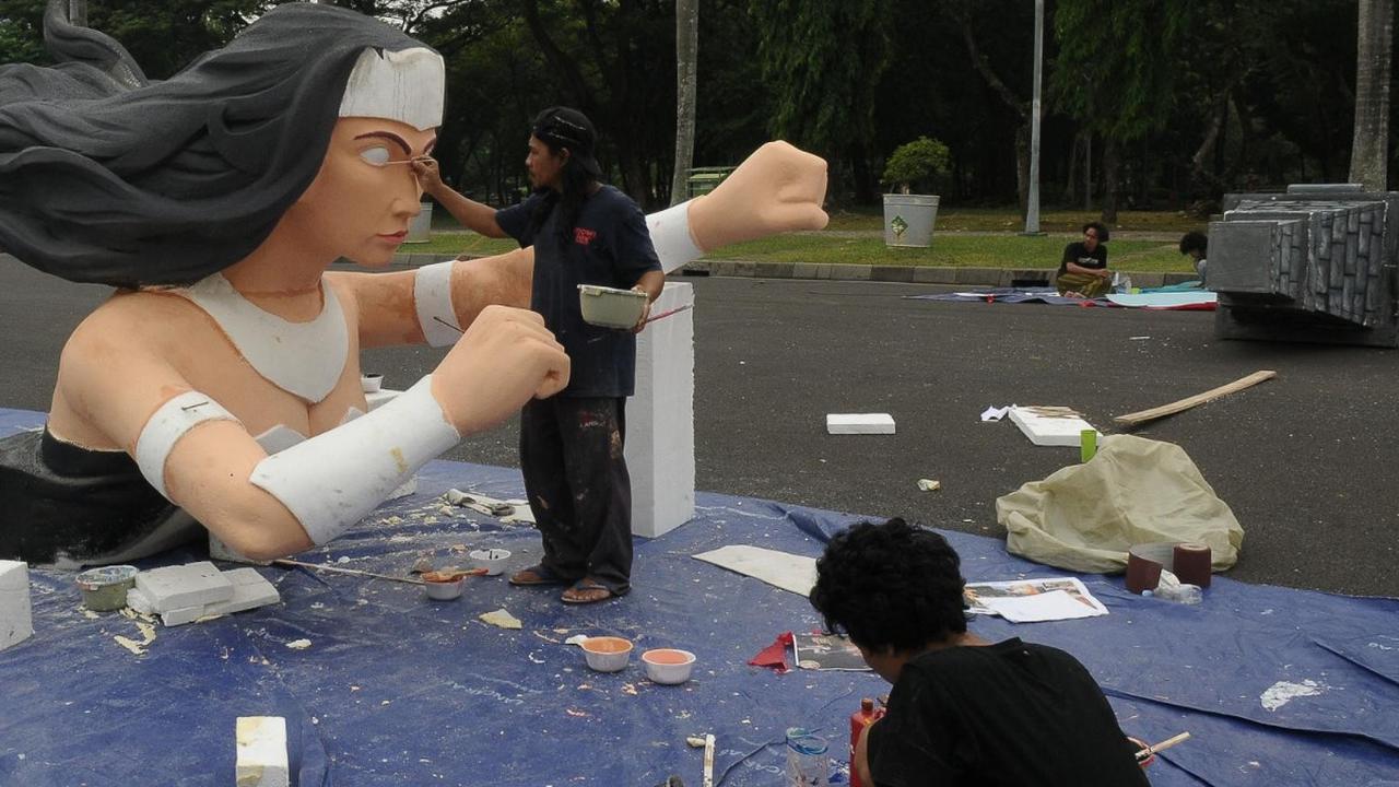 Pekerja seni sedang  menyelesaikan pembuatan patung untuk mobil hias jelang acara Jakarnaval untuk malam Tahun Baru 2024 di Silang Monas, Jakarta, Selasa (26/12/2023).