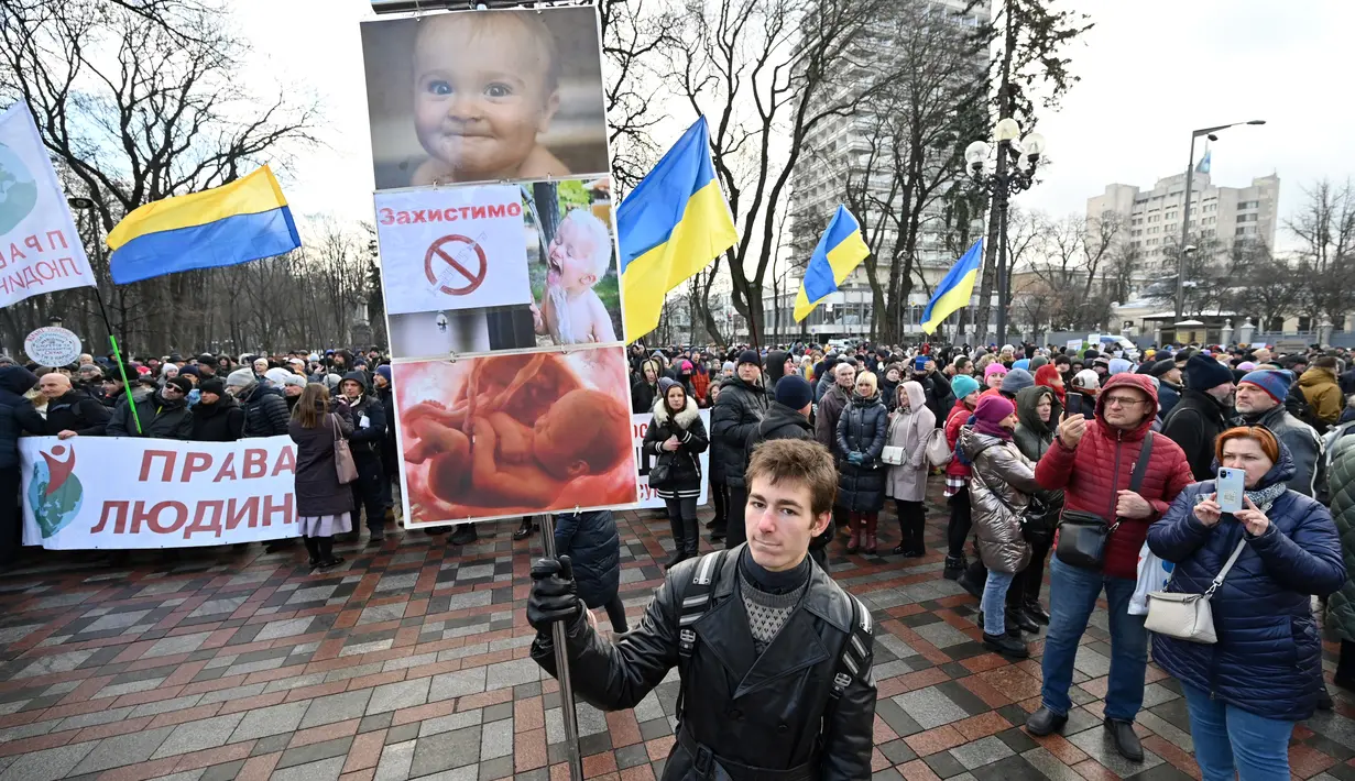 Demonstran anti-vaksin berunjuk rasa di Kiev (24/11/2021). Ratusan pengunjuk rasa memblokir jalan-jalan di pusat kota Kiev pada 24 November untuk berdemonstrasi menentang langkah-langkah anti-Covid Ukraina dan upaya vaksin, saat negara itu memerangi gelombang infeksi baru. (AFP/Genya Savilov)
