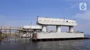 Pekerja menyelesaikan pembangunan jembatan penghubung Dadap Tangerang-Pulau C di Kamal Muara, Penjaringan, Jakarta Utara, Minggu (17/11/2019). Pembangunan jembatan tersebut menyulitkan transportasi nelayan karena perairan menjadi sempit dan laut menjadi dangkal. (merdeka.com/Iqbal Nugroho)
