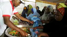 Sejumlah wanita Somalia ketika mendapatkan iftar (makanan berbuka puasa) dari sebuah organisasi amal Qatar selama bulan suci Ramadan, di ibukota Mogadishu, Senin (22/6/2015). (REUTERS/Feisal Omar)