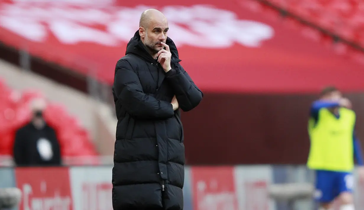 Pelatih Manchester City, Pep Guardiola menyaksikan para pemainnya bertanding melawan Chelsea pada pertandingan semifinal Piala FA di Stadion Wembley di London, Inggris, Minggu (18/4/2021). Kemenangan atas City mengantar Chelsea melaju ke Final Piala FA. (Adam Davy, Pool via AP)