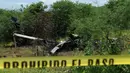 Garis polisi dipasang di dekat jatuhnya helikopter polisi yang diduga ditembak sekelompok geng kartel narkoba di Michoacan, Meksiko, Rabu (7/9). Helikopter itu sedang mendukung operasi penangkapan terhadap para pemimpin geng kriminal. (PEDRO PARDO/AFP)