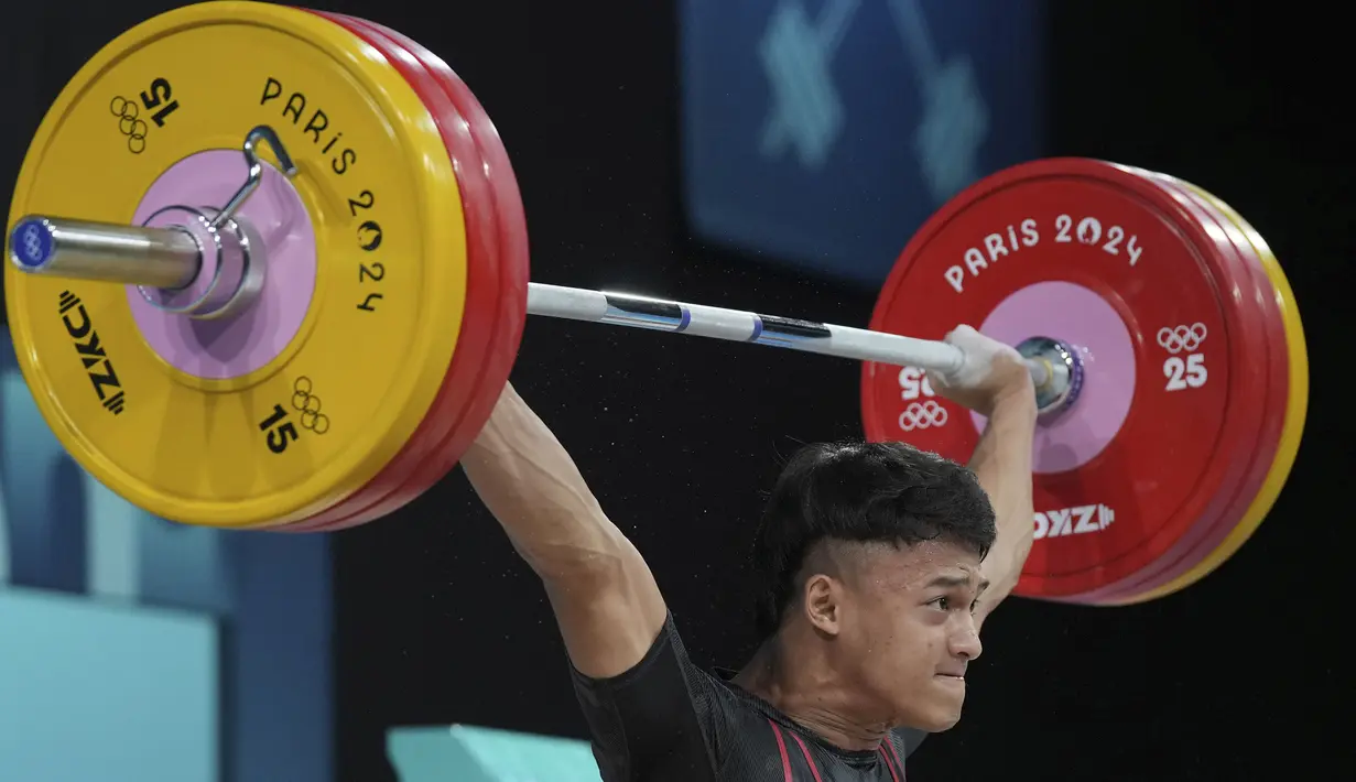 Atlet angkat besi Indonesia, Rizki Juniansyah berhasil mengangkat beban seberat 155 kg pada angkatan snatch saat berlomba pada kelas 73 kg putra cabor angkat besi Olimpiade Paris 2024 di Paris Expo Porte de Versailles, Paris, Kamis (8/8/2024). (AP Photo/Kin Cheung)