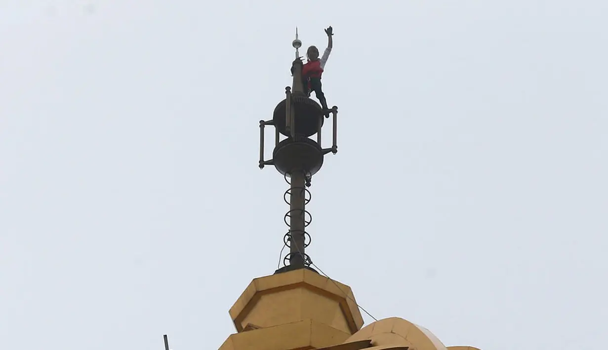  Ekspresi kebahagiaan Alain robert mengepalkan tangannya saat berada di puncak gedung di Macau, Rabu (23/4/2014) (Reuters/Bobby Yip).