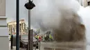 Sebuah pipa uap meledak menyebabkan gumpalan besar asap putih mengepul di Distrik Flatiron, Manhattan, Kamis (19/7). Ledakan itu mendorong pihak berwenang untuk mengevakuasi 28 bangunan sebagai tindakan pencegahan. (AP Photo/Richard Drew)