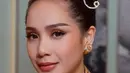 Wajahnya juga tampak dikontur halus, ditambah aplikasi bronzer coklat muda yang beri efek rona kulit hangat. Kemudian pipinya diaplikasikan blush on warna coral yang segar. [@raffinagita1717/@erniaredberry]