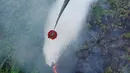 Sebuah helikopter melakukan pengeboman air untuk memadamkan kebakaran lahan gambut di Danau Lamo, Provinsi Jambi, Indonesia, pada hari Senin, 24 Agustus 2026. (BPBD Jambi via AP)