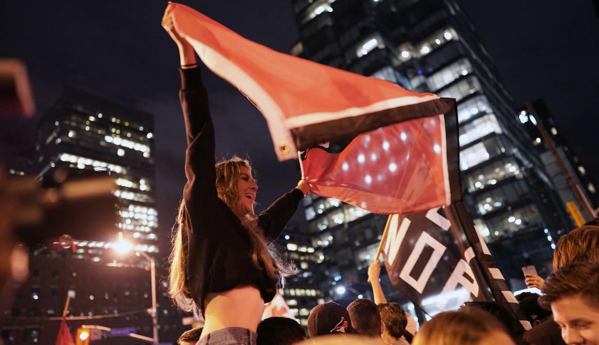 Fans Toronto Raptors merayakan kemenangan Toronto Raptors meraih titel juara NBA 2019 di pusat kota Toronto, Ontario Kanada. (AFP/Geoff Robins)