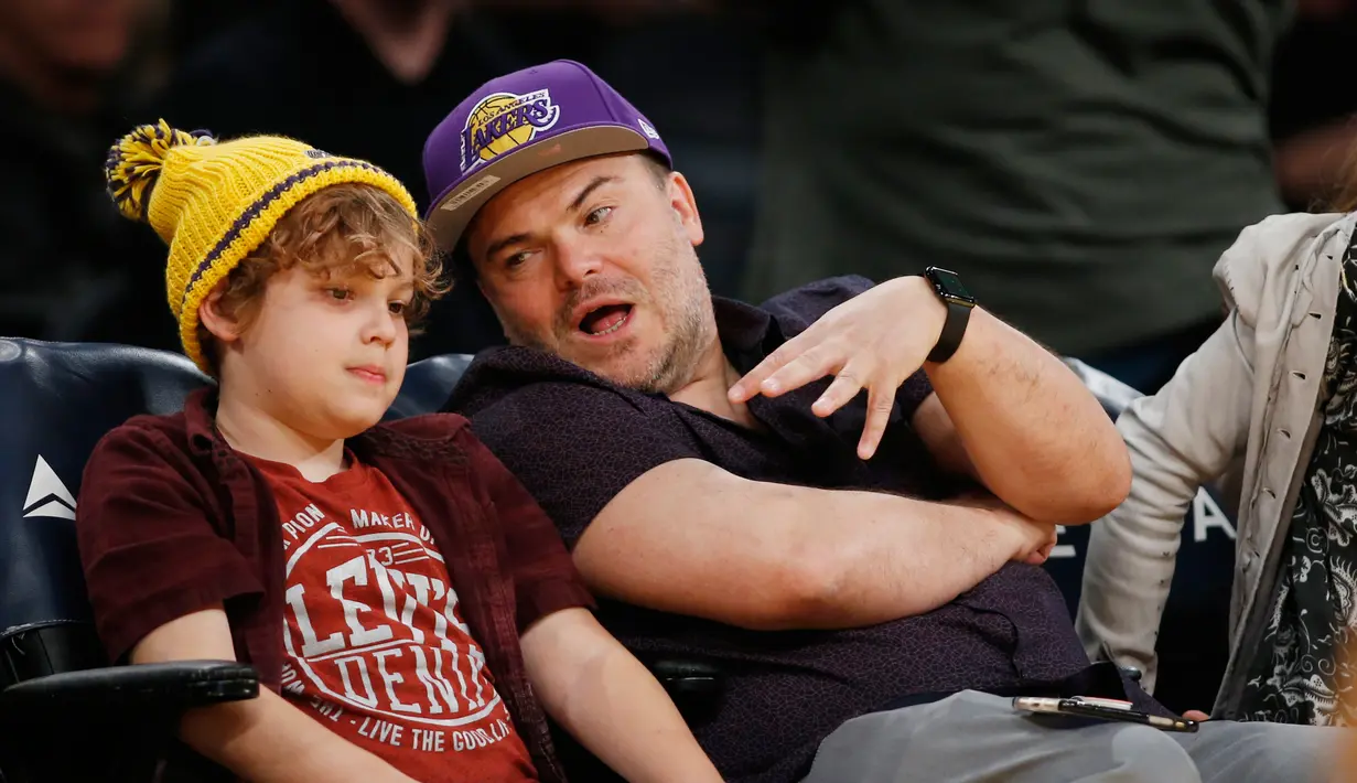 Aktor Jack Black bersama anaknya, Samuel Black duduk ditepi lapangan menonton pertandingan NBA antara Los Angeles Lakers melawan Washington Wizards di Los Angeles (28/3). (AP Photo/Danny Moloshok)