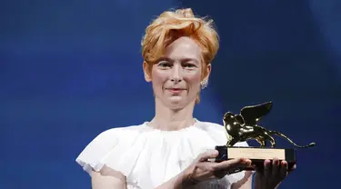 Aktris Tilda Swinton memegang trofi Golden Lion for Lifetime Achievement pada upacara pembukaan Venice Film Festival ke-77 di Venesia, Italia, Rabu (2/9/2020). Venice Film Festival tahun ini akan berlangsung dari 2 September hingga 12 September. (AP Photo/Domenico Stinellis)