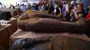 Sejumlah orang mengamati peti mati kuno yang baru ditemukan di situs pemakaman Saqqara di Provinsi Giza, Mesir, 3 Oktober 2020. Kementerian Pariwisata dan Kepurbakalaan Mesir memamerkan 59 peti mati kuno yang baru ditemukan dengan kondisi terawat baik di Provinsi Giza. (Xinhua/Ahmed Gomaa)