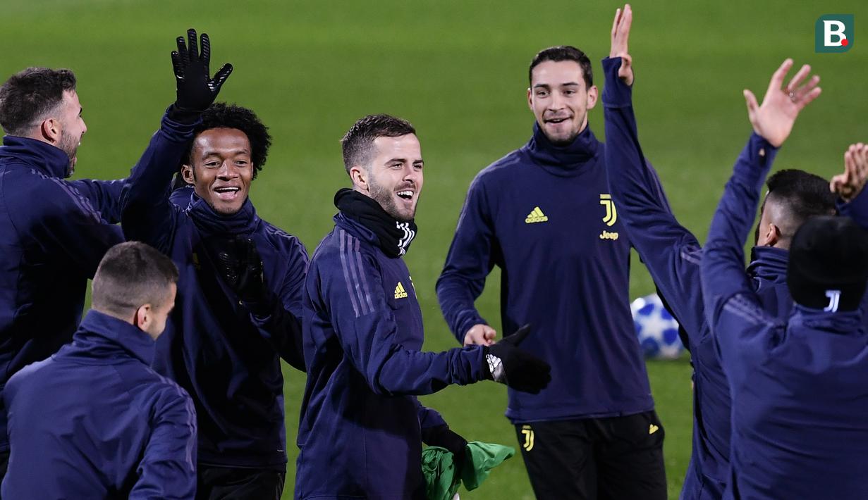 Pemain Juventus, Miralem Pjanic, tertawa saat latihan di Stadion Allianz, Turin, Senin (26/11). Latihan ini persiapan jelang laga Liga Champions melawan Valencia. (AFP/Marco Bertorello)