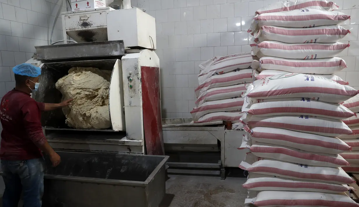 Seorang pekerja roti Palestina membuat roti di Kota Gaza, pada  12 Maret 2022. Melonjaknya harga energi dan makanan yang dipicu oleh invasi Rusia ke Ukraina mendorong beberapa negara Timur Tengah ke tepi jurang.  (AP Photo /Adel Hana)