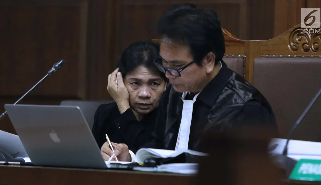 Hakim ad hoc nonaktif Pengadilan Tipikor Medan, Merry Purba (kiri) saat sidang di Pengadilan Tipikor, Jakarta, Kamis (21/2). Merry Purba tetap menjalani sidang meski dalam suasana berduka setelah suaminya meninggal dunia. (Liputan6.com/Helmi Fithriansyah)