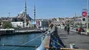 Seorang pria memancing di Jembatan Galata di Istanbul, Turki pada Senin (17/5/2021). Pemerintah Turki mencabut lockdown atau penguncian penuh selama 17 hari untuk mengekang lonjakan infeksi virus corona COVID-19. (OZAN KOSE / AFP)