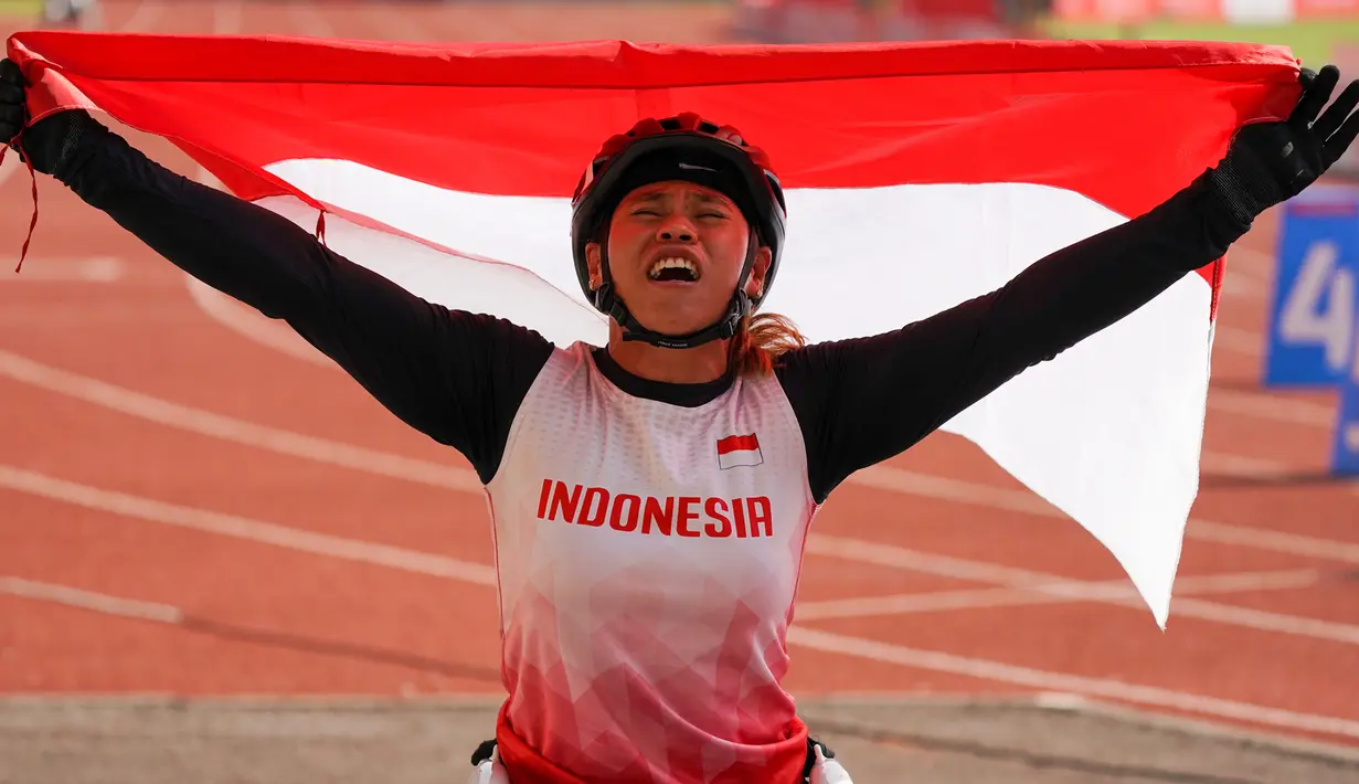 Atlet balap kursi roda Maria Goreti melakukan selebrasi usai memenangi final balap kursi roda 400 meter putri 11th ASEAN Para Games 2022 di Stadion Manahan, Solo, Jawa Tengah, kamis (4/8/2022). Maria Goreti meraih medali emas pada final tersebut. (INASPOC/Feri Setiawan)