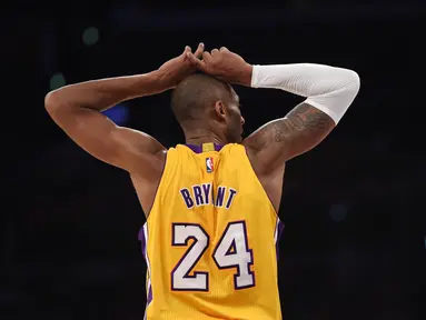Kobe Bryant bereaksi setelah melakukan pelanggaran saat pertandingan LA Lakers melawan Memphis Grizzlies dalam laga basket NBA di Staples Center, Los Angeles, California, AS, (26/11/2014). (AFP/Robyn Beck)