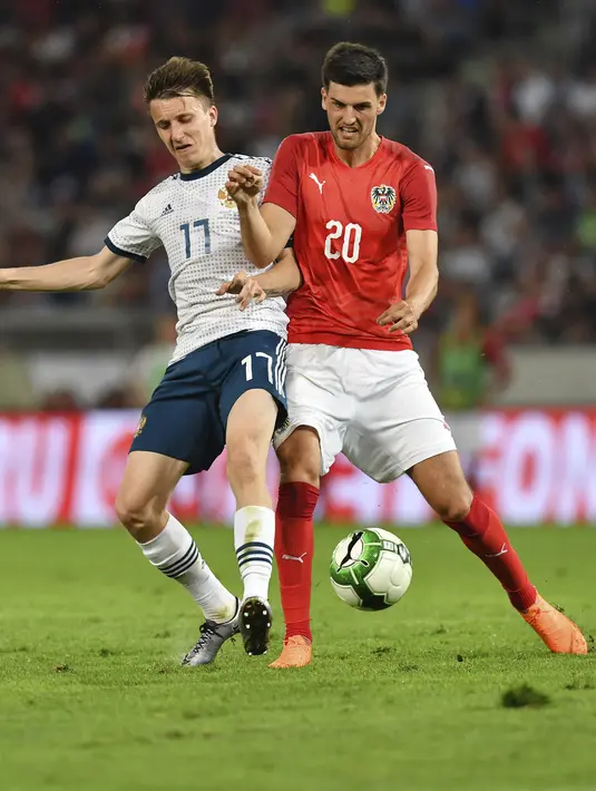Pemain Austria, Florian Grillitsch (kanan) dan pemain Rusia saling berebut bola pada laga uji coba di Tivoli Stadium, Innsbruck, Austria, (30/5/2018). Austria menang atas Rusia 1-0. (AP/Kerstin Joensson)