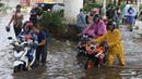 Pengendara terpaksa mendorong motornya yang mogok akibat memaksa melintasi banjir yang menggenangi jalan Ciledug Raya, Jakarta Selatan, Sabtu (6/7/2024). (Liputan6.com/Angga Yuniar)