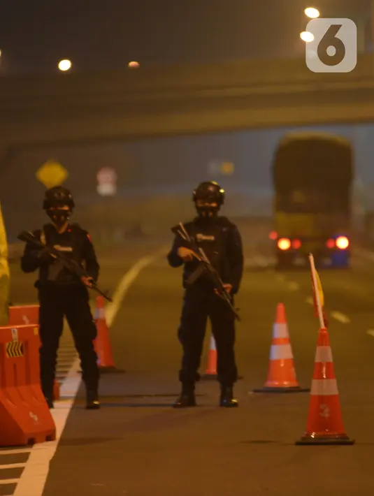 Petugas melakukan penyekatan arus mudik 2021 di gerbang pintu tol Pejagan, Brebes, Jawa Tengah, Jumat (7/5/2021) Tengah Malam, H-5 peniadaan mudik Idul Fitri 1442H dengan petugas gabungan melakukan penjagaan di 6 titik dari kabupaten menjadi pintu masuknya Jawa Tengah. (merdeka.com/Imam Buhori)