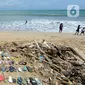 Wisatawan asal Belanda menata sampah sandal dan sepatu yang dia kumpulkan dari Pantai Kuta. (merdeka.com/Arie Basuki)