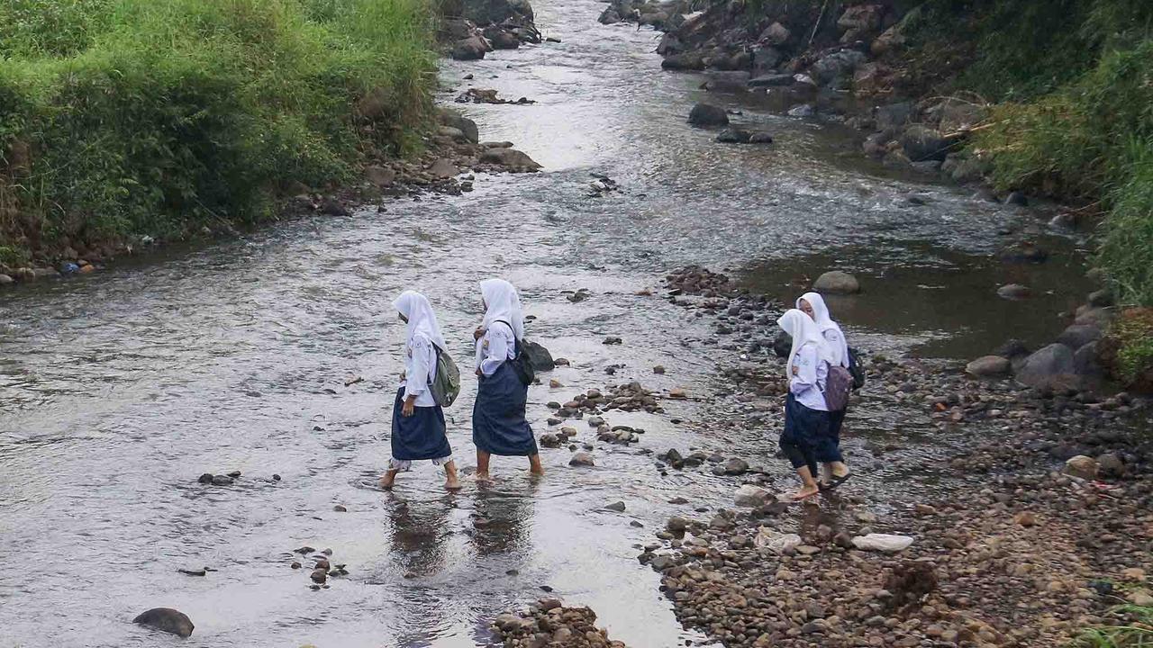 FOTO: Ketiadaan Jembatan  Penghubung Membuat Puluhan Siswa Menyeberang Sungai Menuju Sekolah di Dramaga Bogor