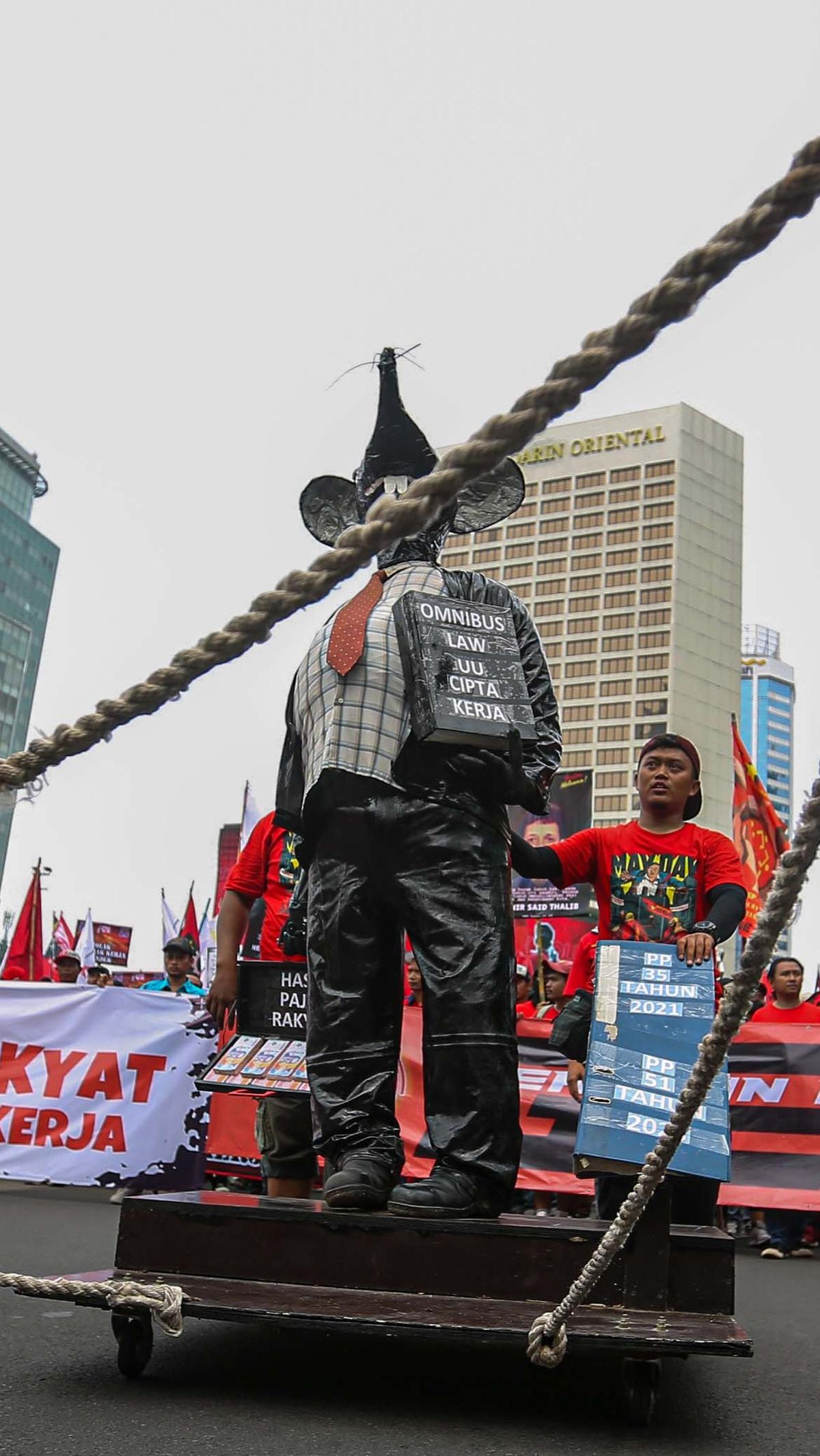 Dalam aksinya, massa buruh tampak membawa 'tikus raksasa' yang memakai dasi dan membawa buku hitam bertuliskan "Omnibus Law UU Cipta Kerja". Foto: Liputan6.com/Angga Yuniar