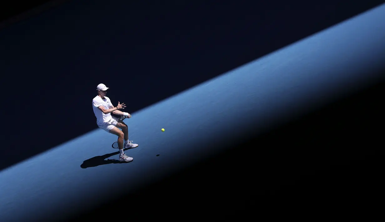Petenis Kanada, Denis Shapovalov melakukan pukulan balik saat melawan petenis Spanyol, Rafael Nadal dalam pertandingan perempat final tunggal putra pada hari kesembilan turnamen tenis Australia Terbuka di Melbourne pada 25 Januari 2022.
(AFP/Martin Keep)