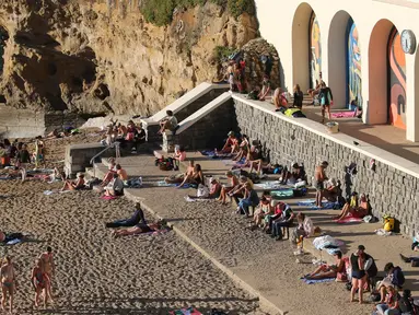 Orang-orang berjemur di pantai Biarritz, barat daya Prancis, Rabu (27/10/2021). Suhu di Prancis barat daya mencapai 20 derajat Celcius (68 Fahrenheit). (AP Photo/Bob Edme)