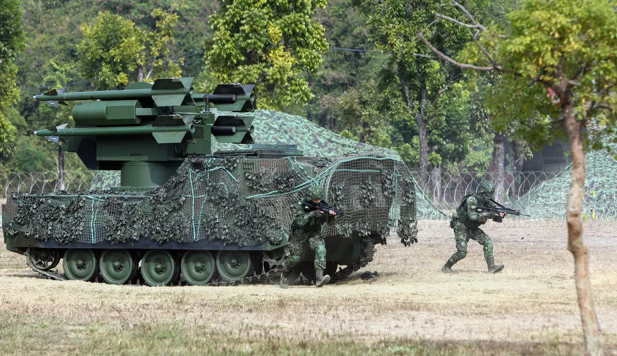 Tentara terlihat di samping kendaraan pertahanan darat-ke-udara saat latihan peningkatan kesiapsiagaan yang mensimulasikan pertahanan terhadap gangguan militer China jelang Tahun Baru Imlek di Kota Kaohsiung, Taiwan, 11 Januari 2023. China memperbarui ancamannya untuk menyerang Taiwan dan memperingatkan bahwa negara tersebut telah "bermain api". (AP Photo/Daniel Ceng)